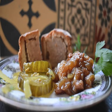 Date and Walnut Christmas Chutney on a plate with bread and butter pickles and pork pies.